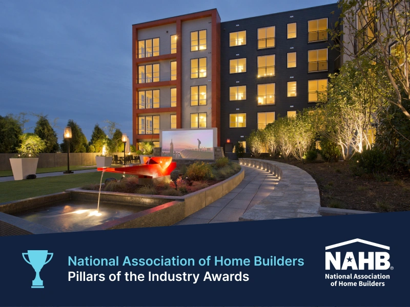 Evening courtyard at Halstead Square featuring lit fountain and modern apartment backdrop