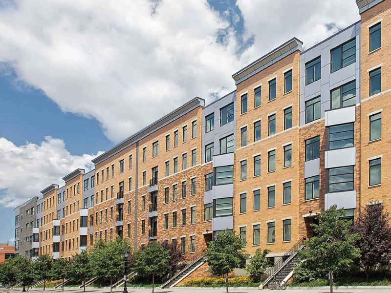 Halstead Madison Apartments complex with modern accents and uniform windows under blue skies