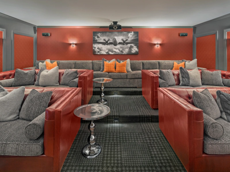 Stylish home theater featuring tiered sofas, accent pillows, and aviation-themed art at Halstead Danvers