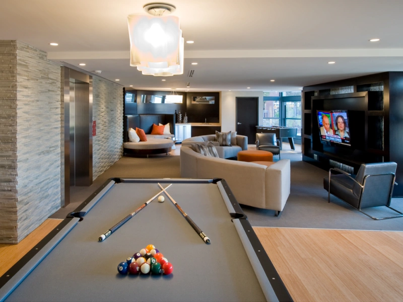 Modern resident lounge featuring pool table, round seating nook and wall-mounted TV in Halstead Arlington