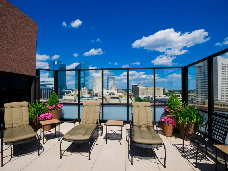 Rooftop terrace lounge with cushioned sun chairs and stunning downtown skyline views at Halstead White Plains