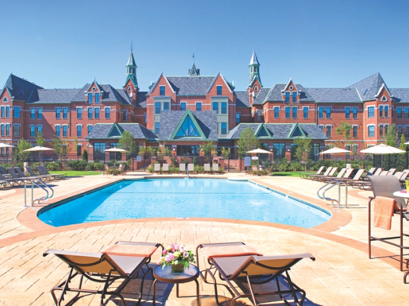 Luxury apartment pool with stately Victorian-style backdrop at Halstead Danvers, MA