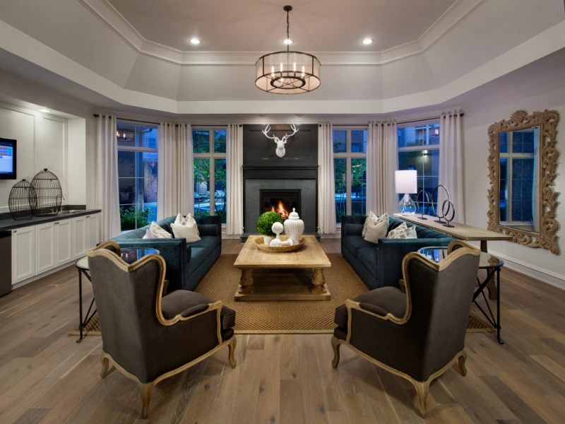 Sophisticated apartment lounge with dark sofas, fireplace centerpiece, and decorative lighting fixtures