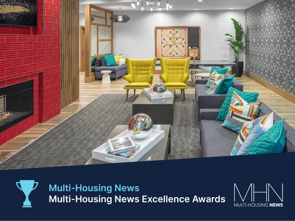 Boldly styled community room with yellow chairs, patterned walls, and red fireplace surround