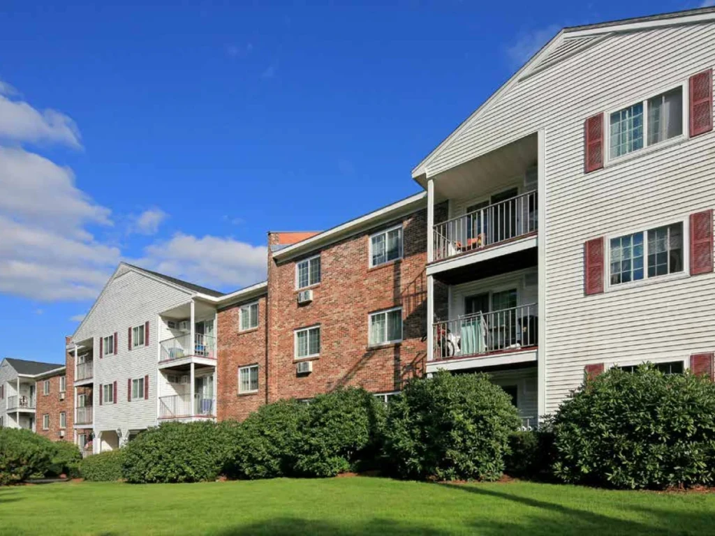 Exterior view of Manchester apartment complex acquired by DSF Group with landscaped greenery