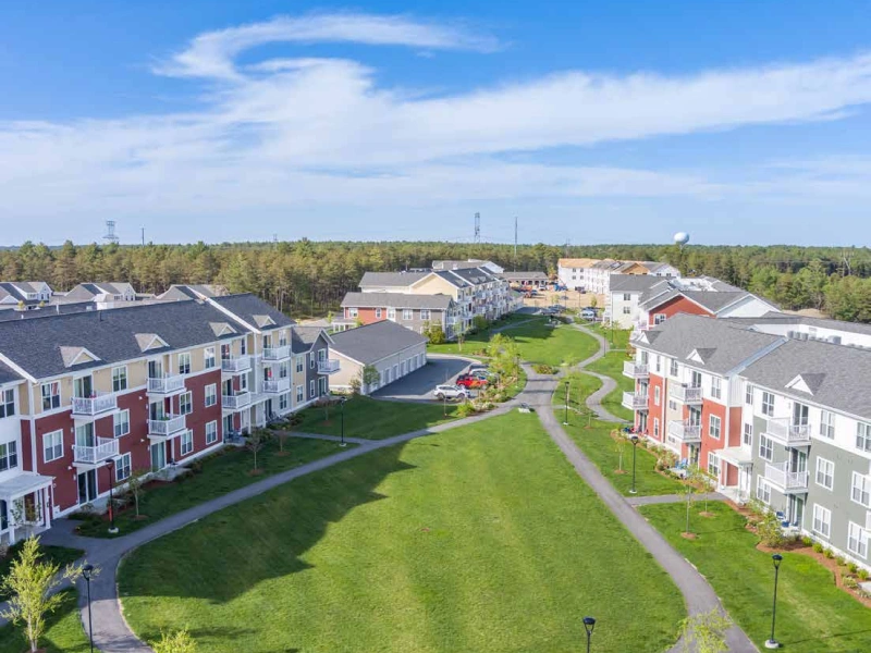 Aerial view of modern apartment buildings surrounding expansive green space in a suburban neighborhood