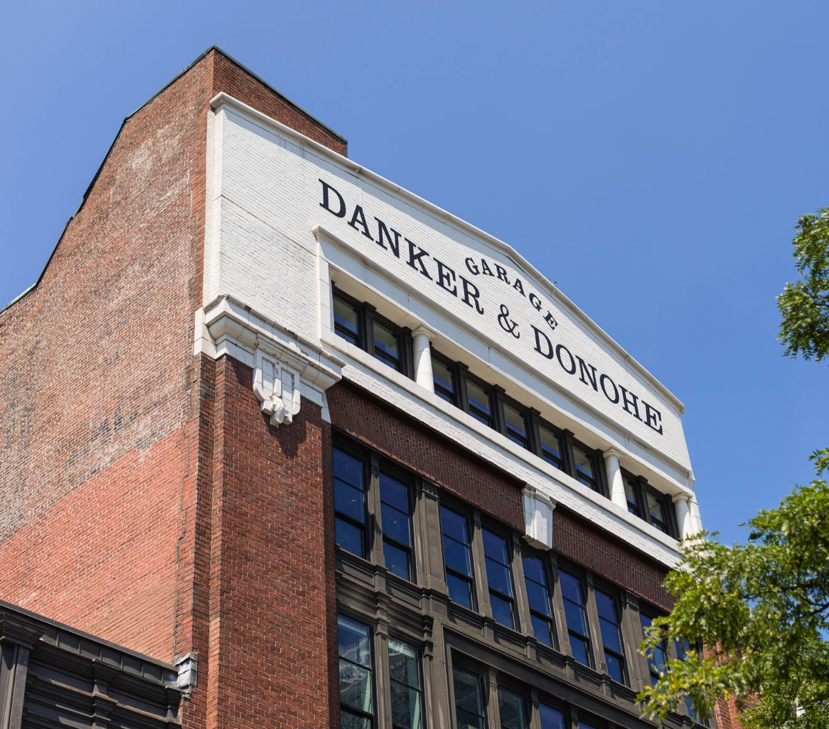 Historic brick building facade with Danker & Donohe signage against a clear blue sky