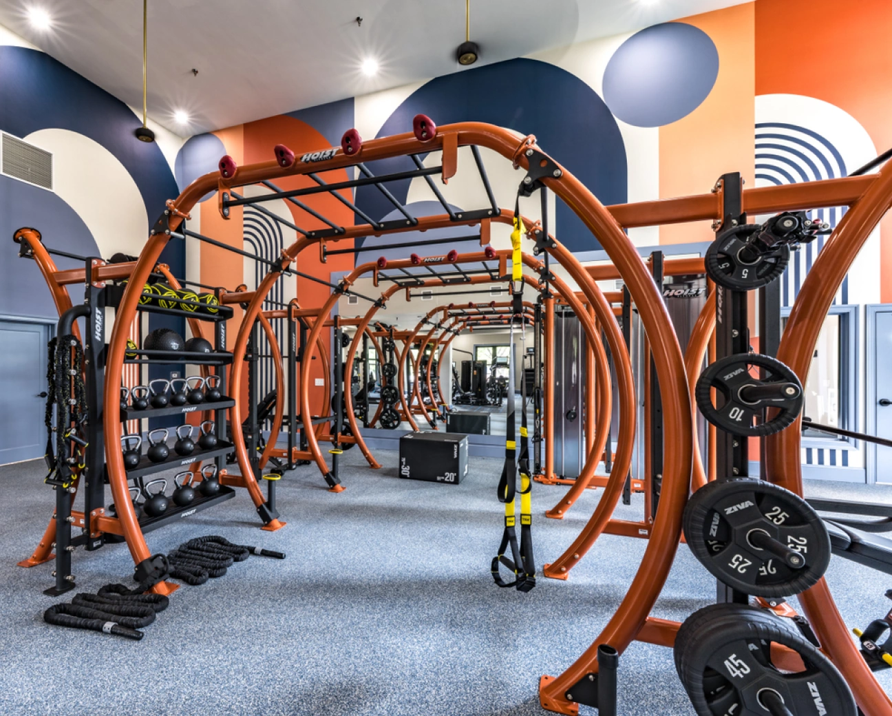 Innovative gym facility with advanced fitness equipment and dynamic geometric wall design