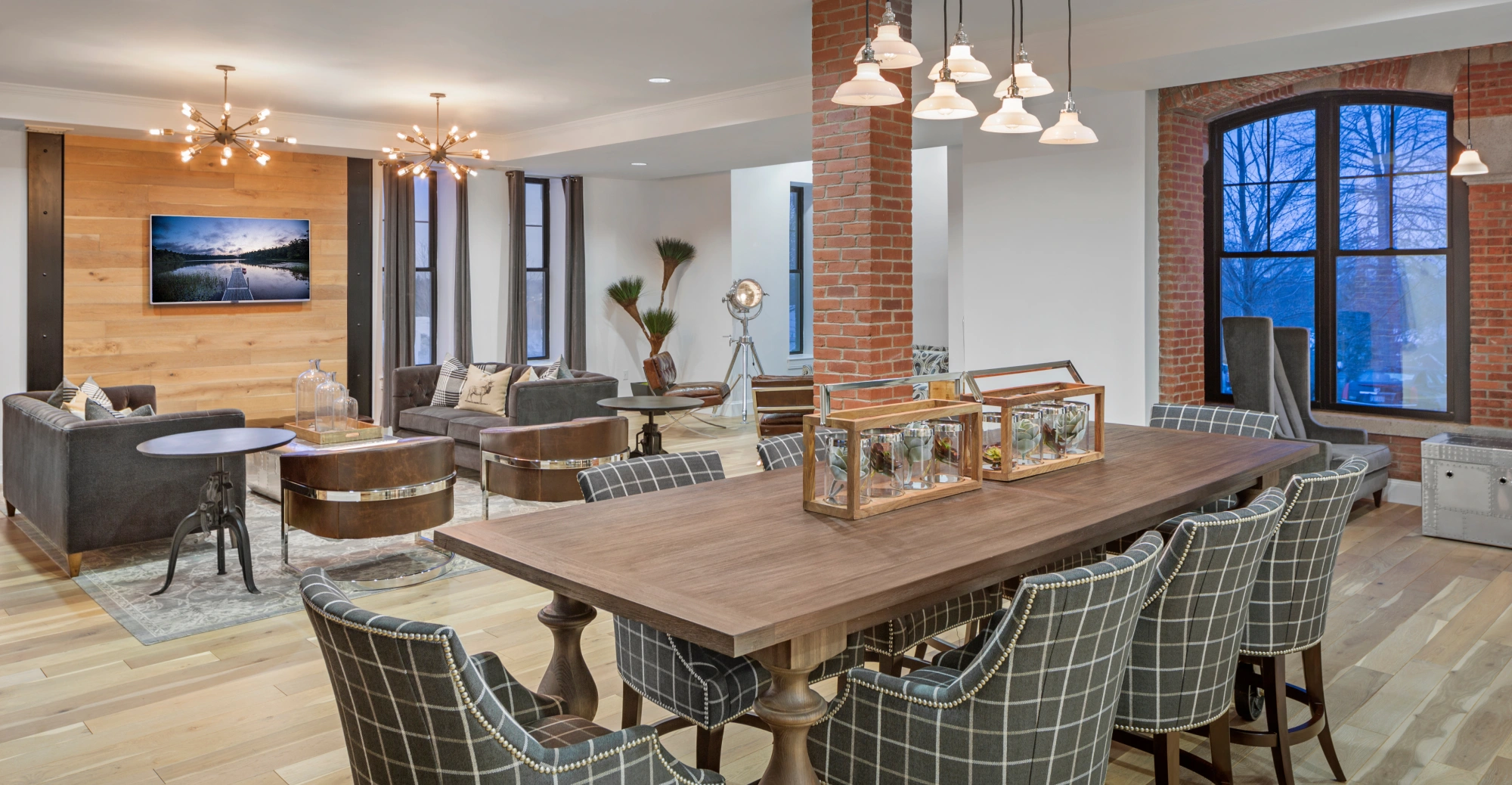 Elegant open lounge and dining area with modern lighting and wood-accented feature wall in Halstead Danvers