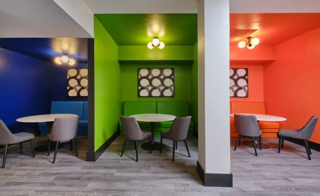 Colorful study booths in green, blue, and orange with round tables and soft chairs in Halstead Framingham