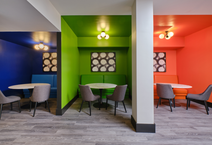 Colorful study booths in green, blue, and orange with round tables and soft chairs in Halstead Framingham