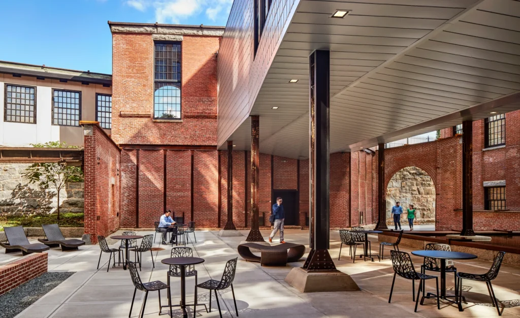 Outdoor courtyard with modern seating, exposed brick architecture, and covered walkway area in Halstead Providence