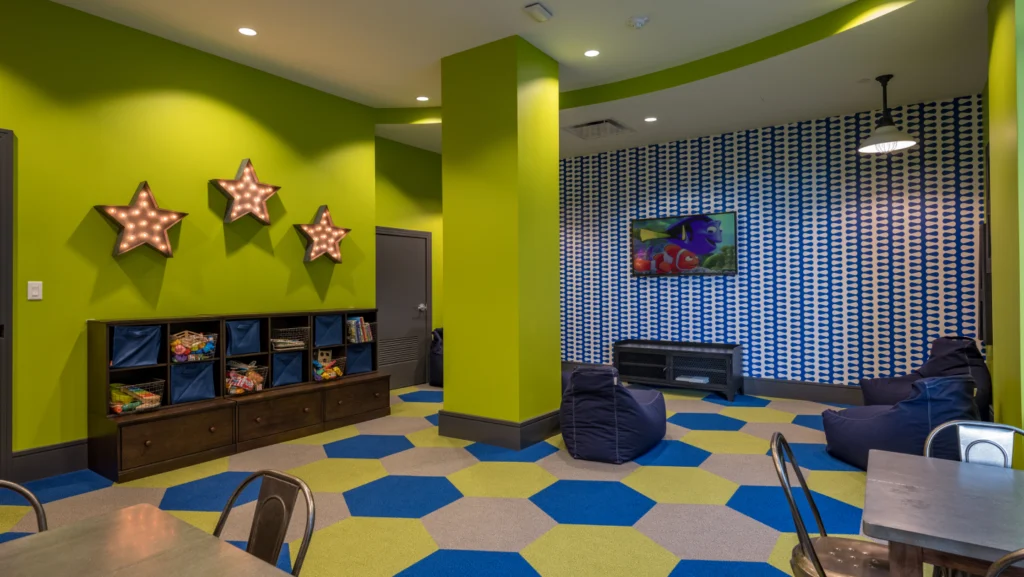 Bright and colorful kids playroom with toy storage, bean bags, and a cartoon-themed TV